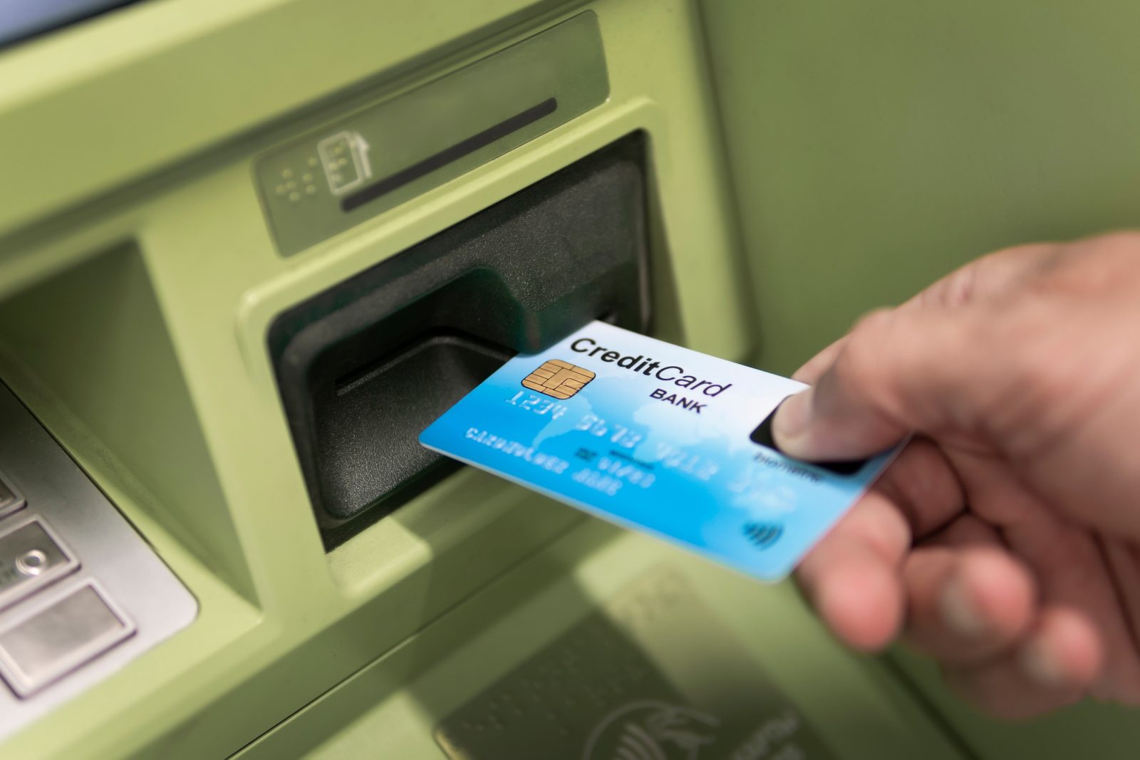 Man,Hand,Puts,Credit,Card,Into,Atm