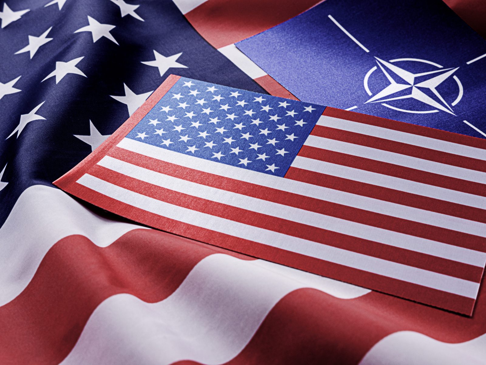 NATO after US elections symbol in front of American flag representing NATO US alliance