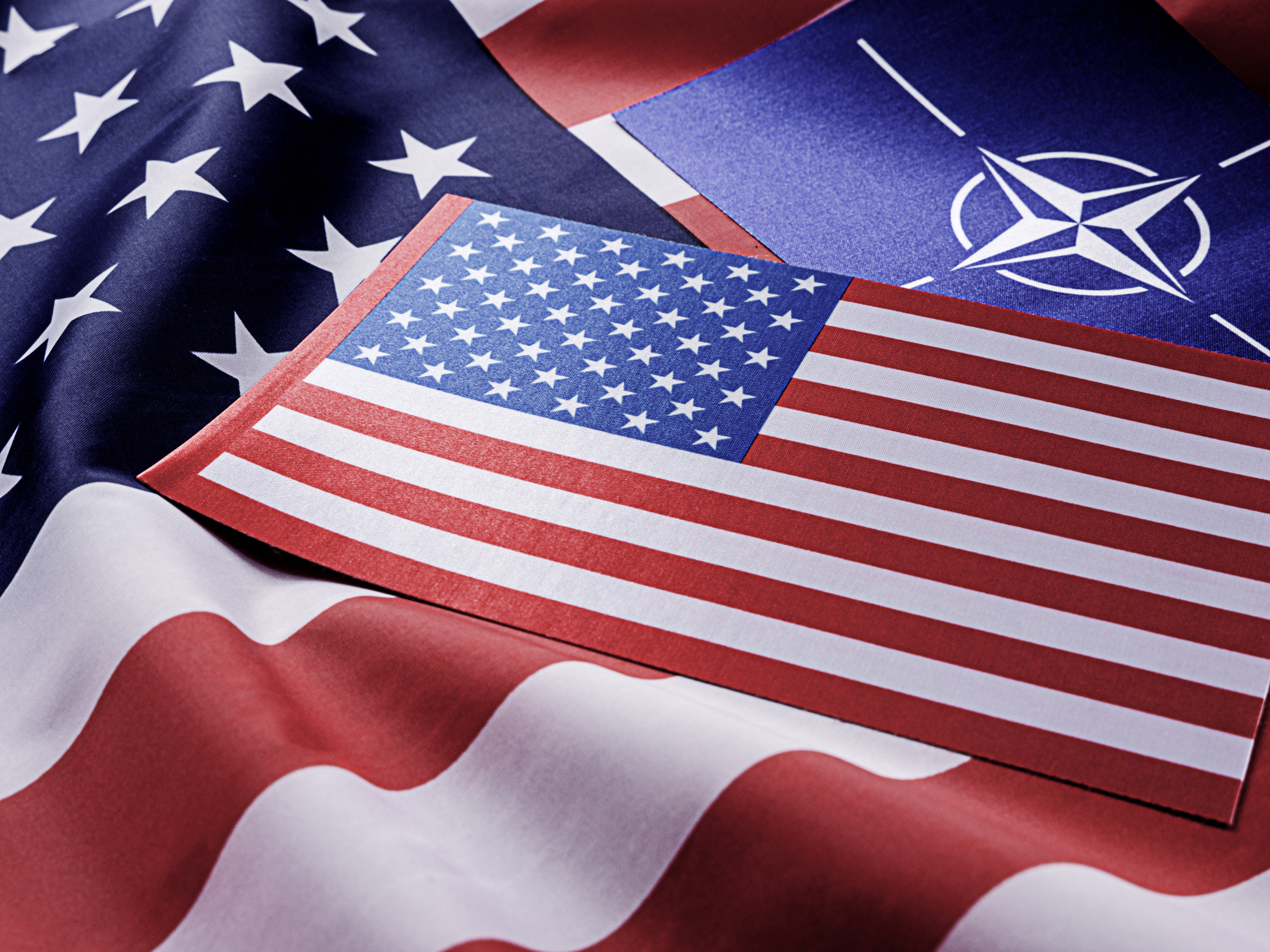 NATO after US elections symbol in front of American flag representing NATO US alliance
