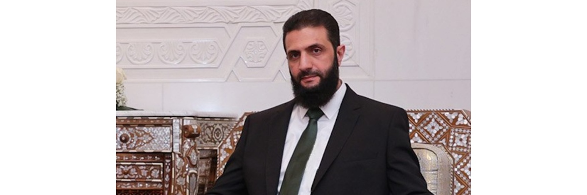 Abu Mohammed al Golani Abu Mohammed al Golani wearing a black suit and posing for the camera