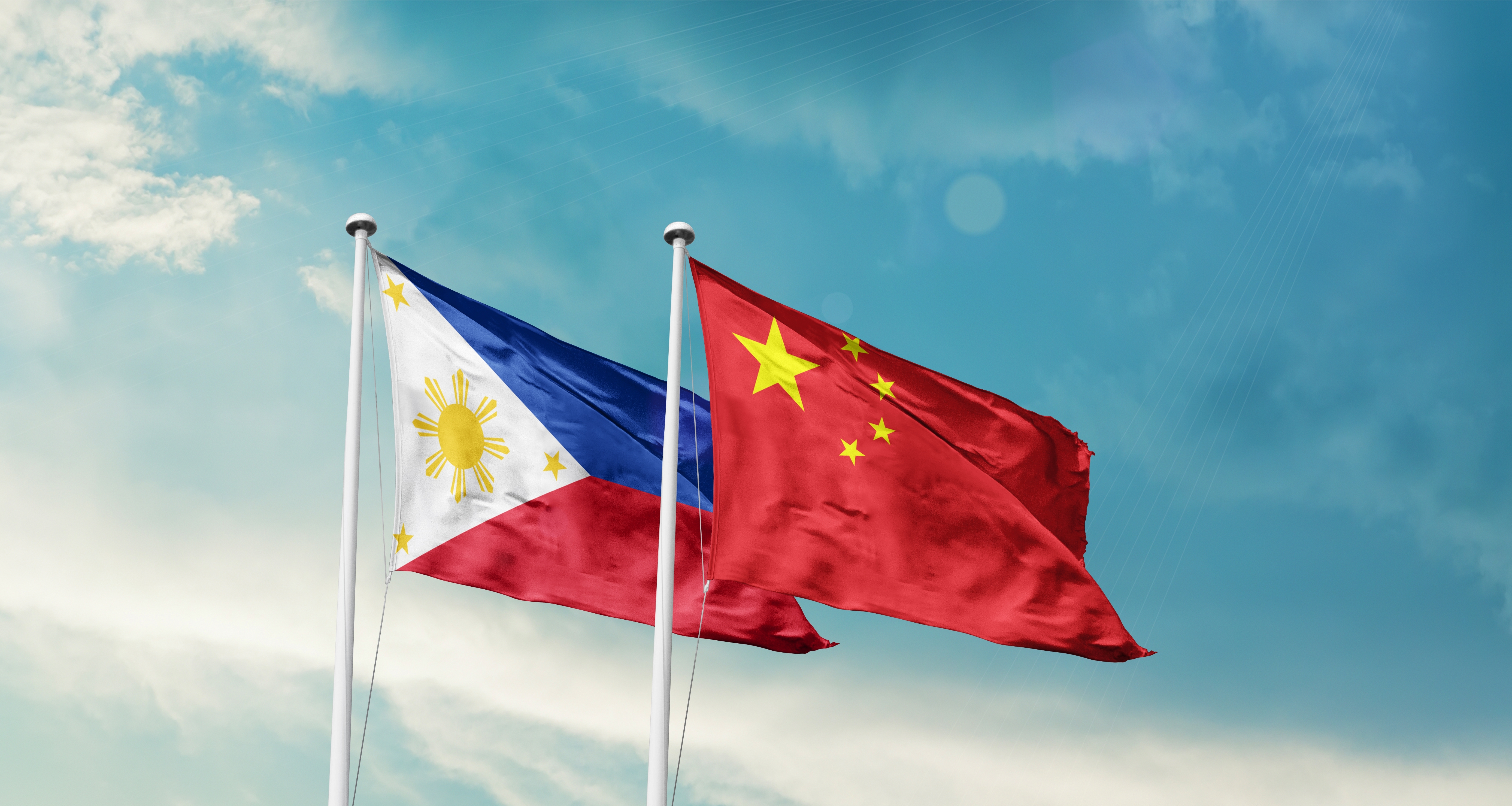 China And The Philippines In The South China Sea Start Philippines and China flags are waving in the sky. Double country Flag waving with mast. Philippines china national flag for agreement.