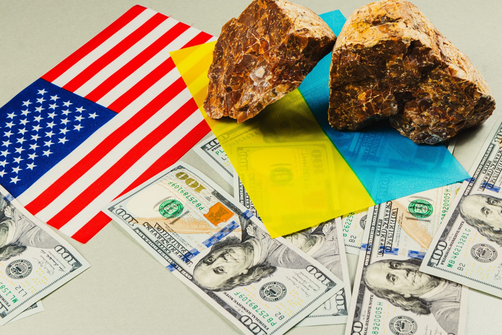 US-Ukraine minerals deal shown with mineral rocks, US currency, and flags of Ukraine and USA highlighting power, resources, and geopolitical interests