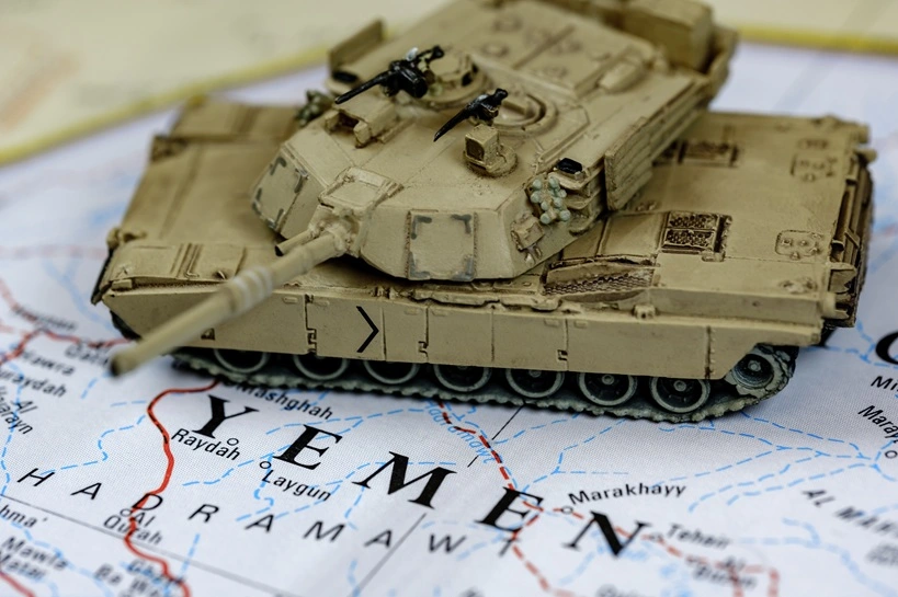 In focus armored tank on top of blurry Yemen map.