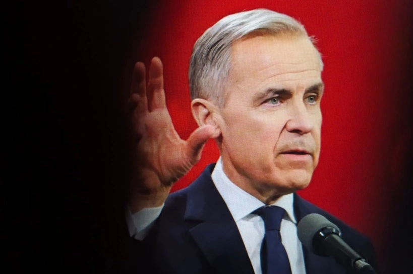 Mark carney, the former governor of the bank of england, speaking at an event with hand in the foreground and red background, New York City, October 7, 2025