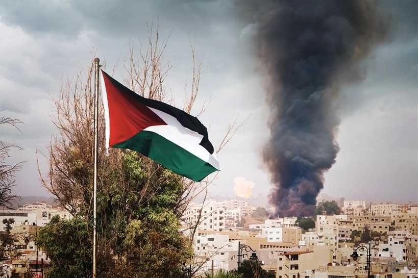 the flag of Palestine on the mountain on the background of the houses in the city. the war in the Middle East. explosion with black smoke in the city.