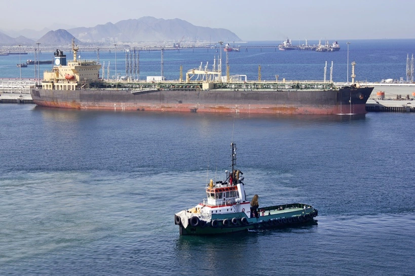 One small boat docked to oil tanker in port of Fujairah (United Arab Emirates)