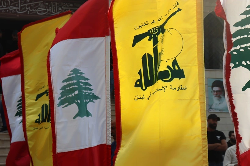 Tyre, South Lebanon – October 26, 2025: Lebanese and Hezbollah flags wave together during a public gathering, reflecting Lebanon’s political symbolism, unity, and underlying tensions. Source: Shutterstock