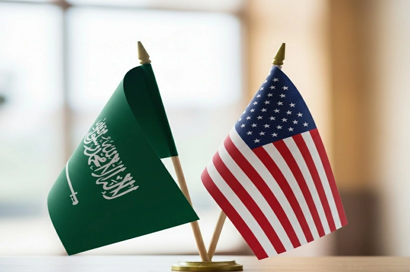 Close-up of Saudi Arabia and United States flags, miniature national symbols representing diplomacy, partnership, and international relations, US flag, KSA flag, Source: Shutterstock