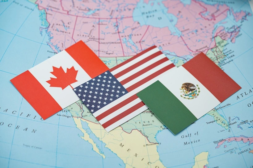 Close up of Canada, United States and Mexico flags on North America map. Source: Shutterstock